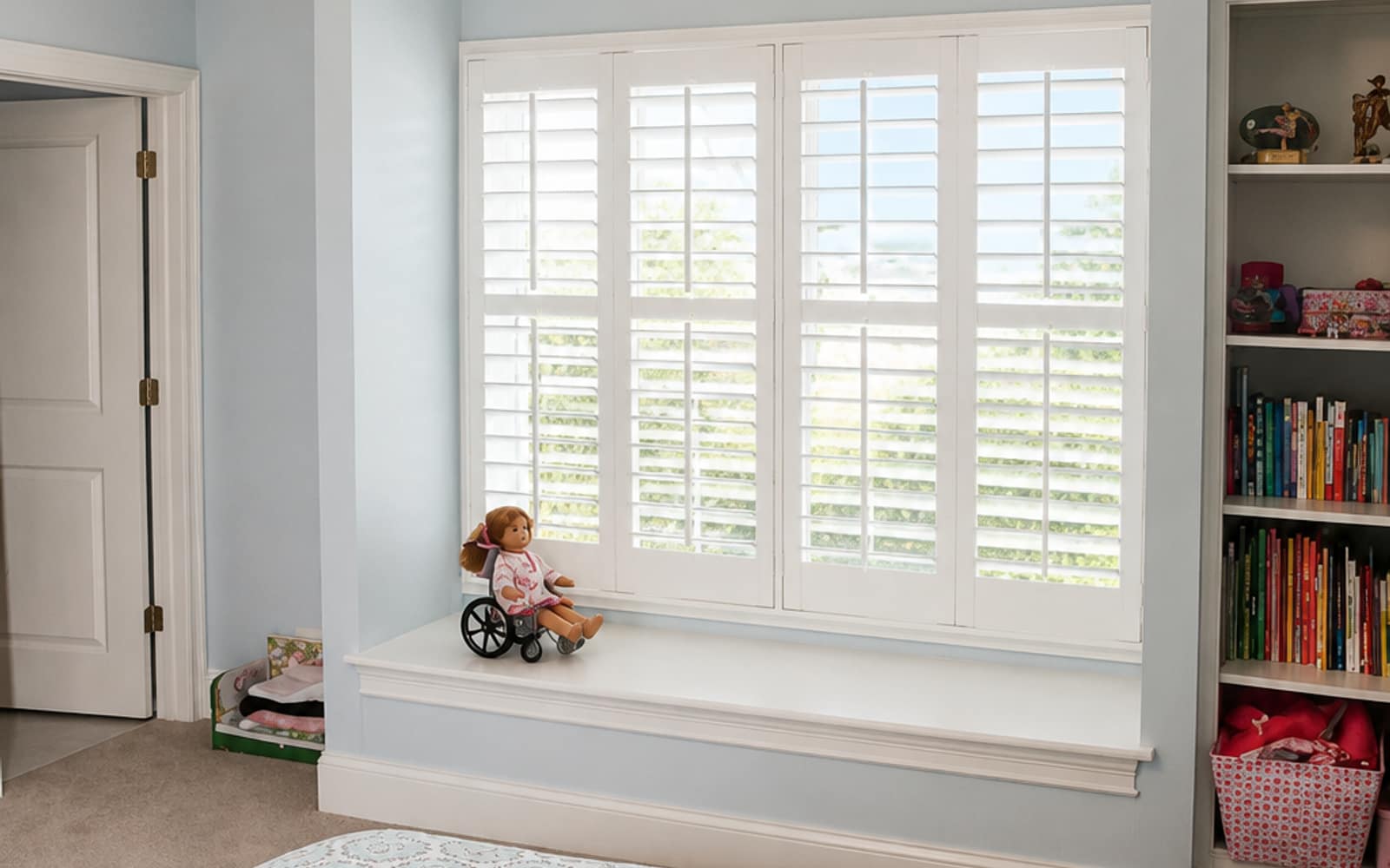 Child's room with a window seat, doll, and built-in bookcase, plantation shutters on the cordless window