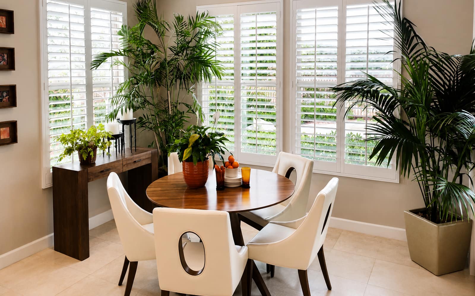 Bright Orange County dining area with a five-window wall, strong afternoon sun, and palm trees outside the glass