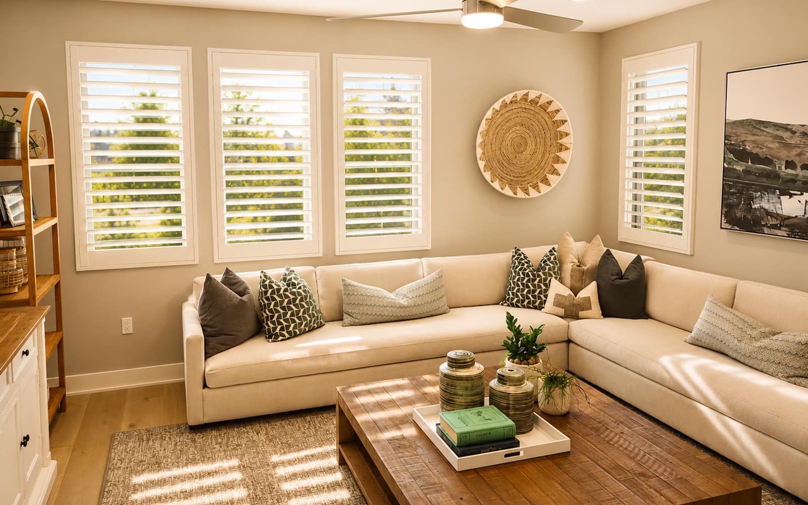Family room with a cream sectional and four windows fitted with clean white plantation shutters that pass HOA review