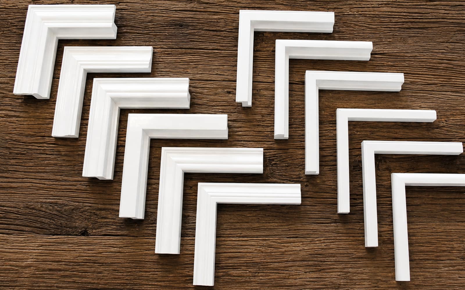 Shutter frame corners and components laid out on a wood table, the parts that make up a custom plantation shutter