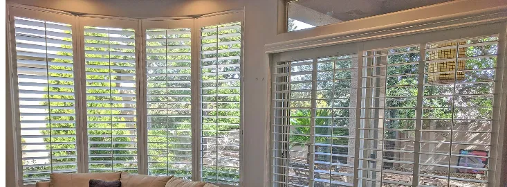 Plantation shutters on a sliding glass door and large living-room windows