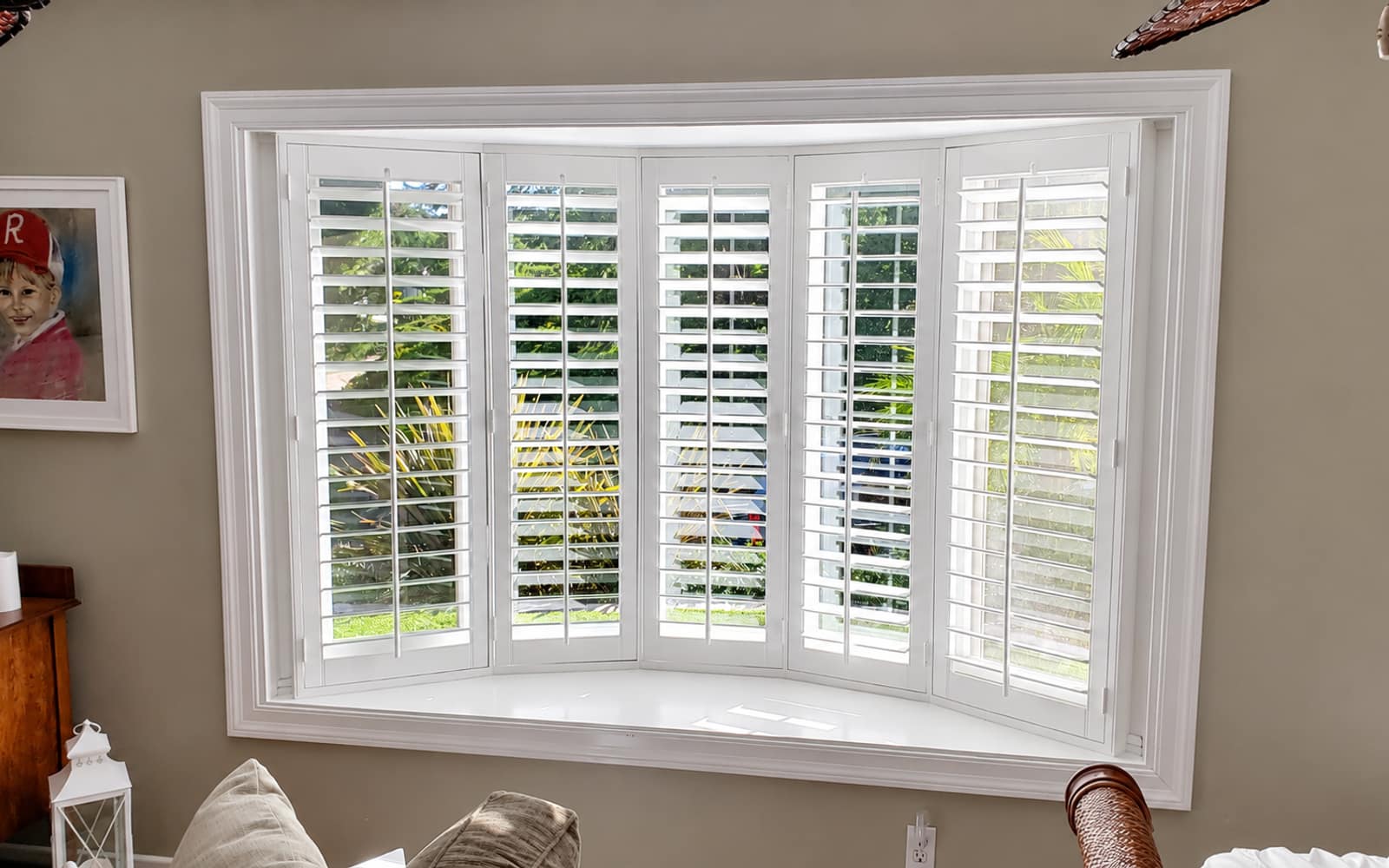 Living room bay window with white plantation shutters across six panels in a Lake Forest whole-home project