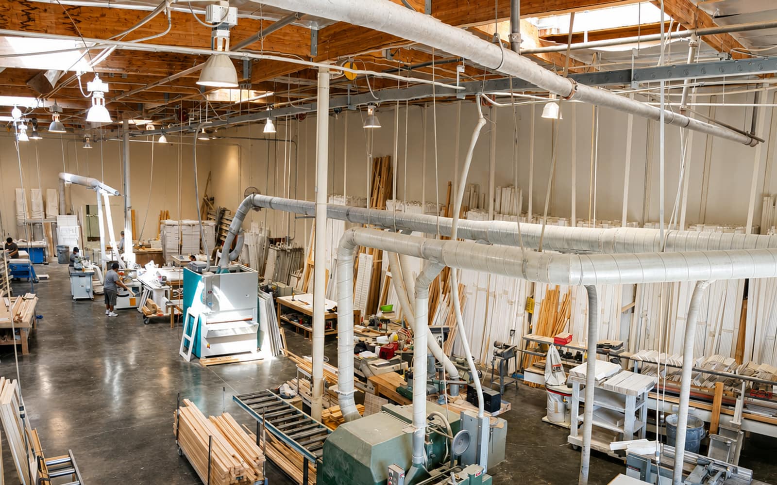 Overhead view of the Golden West factory floor in Lake Forest, with millwork saws and shutter components staged for assembly.