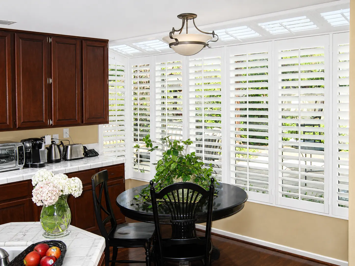 White plantation shutters on a kitchen window over a breakfast nook in Orange