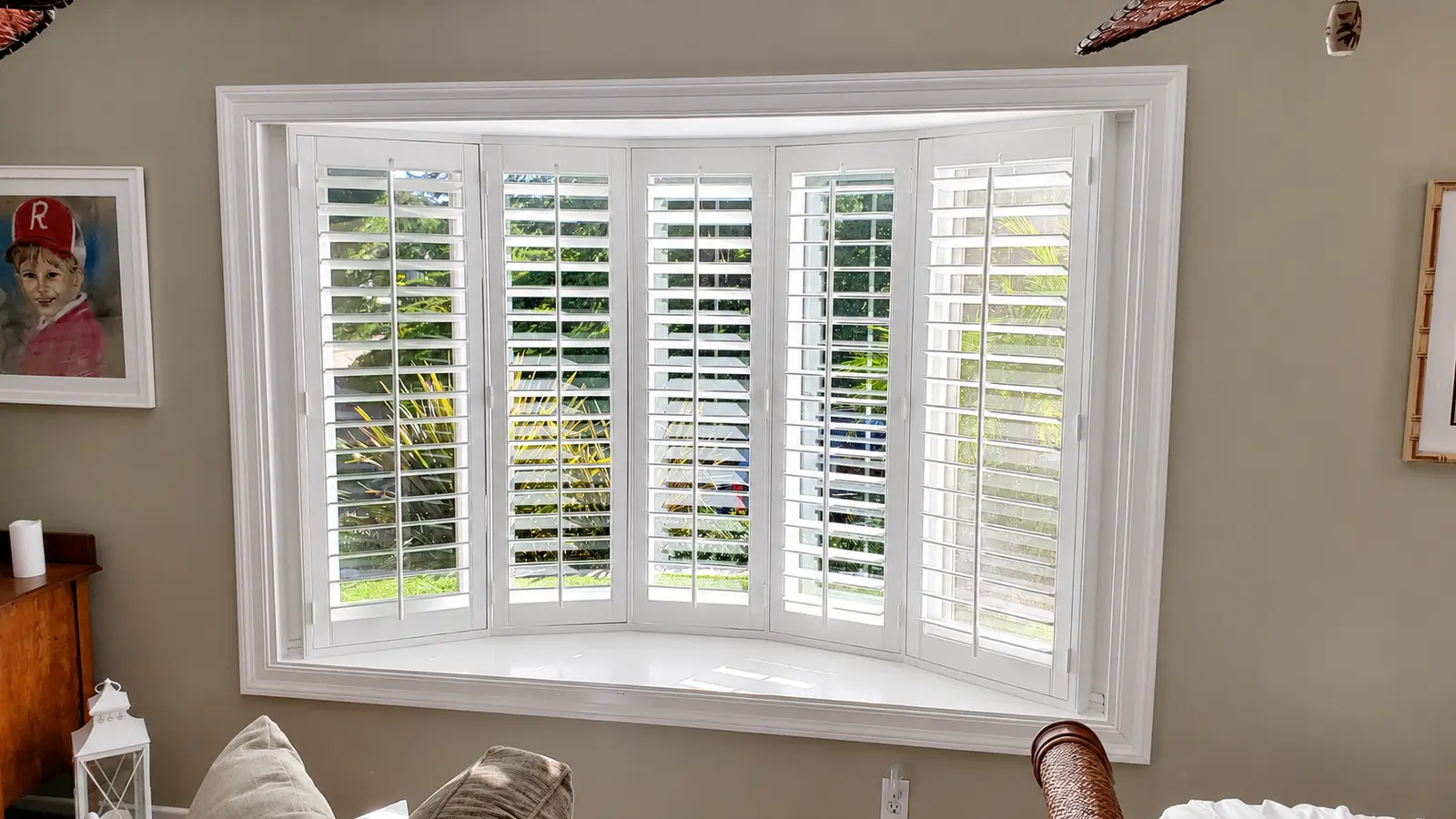 White plantation shutters fanning across a five-panel bay window in Mission Viejo