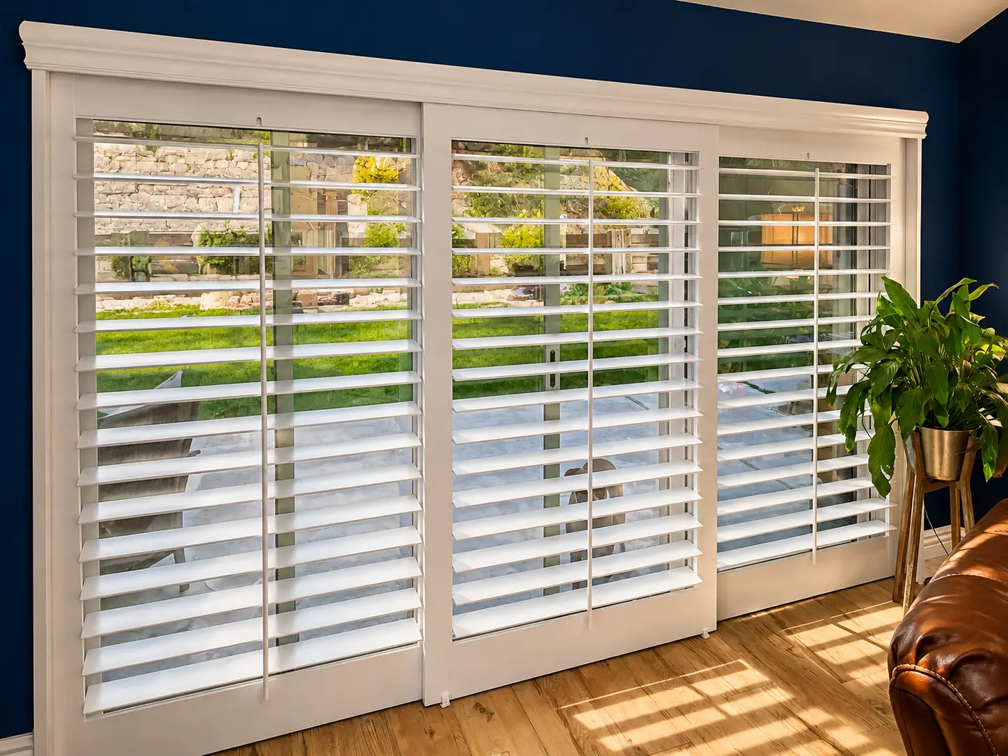 White plantation shutters on three patio doors with backyard view