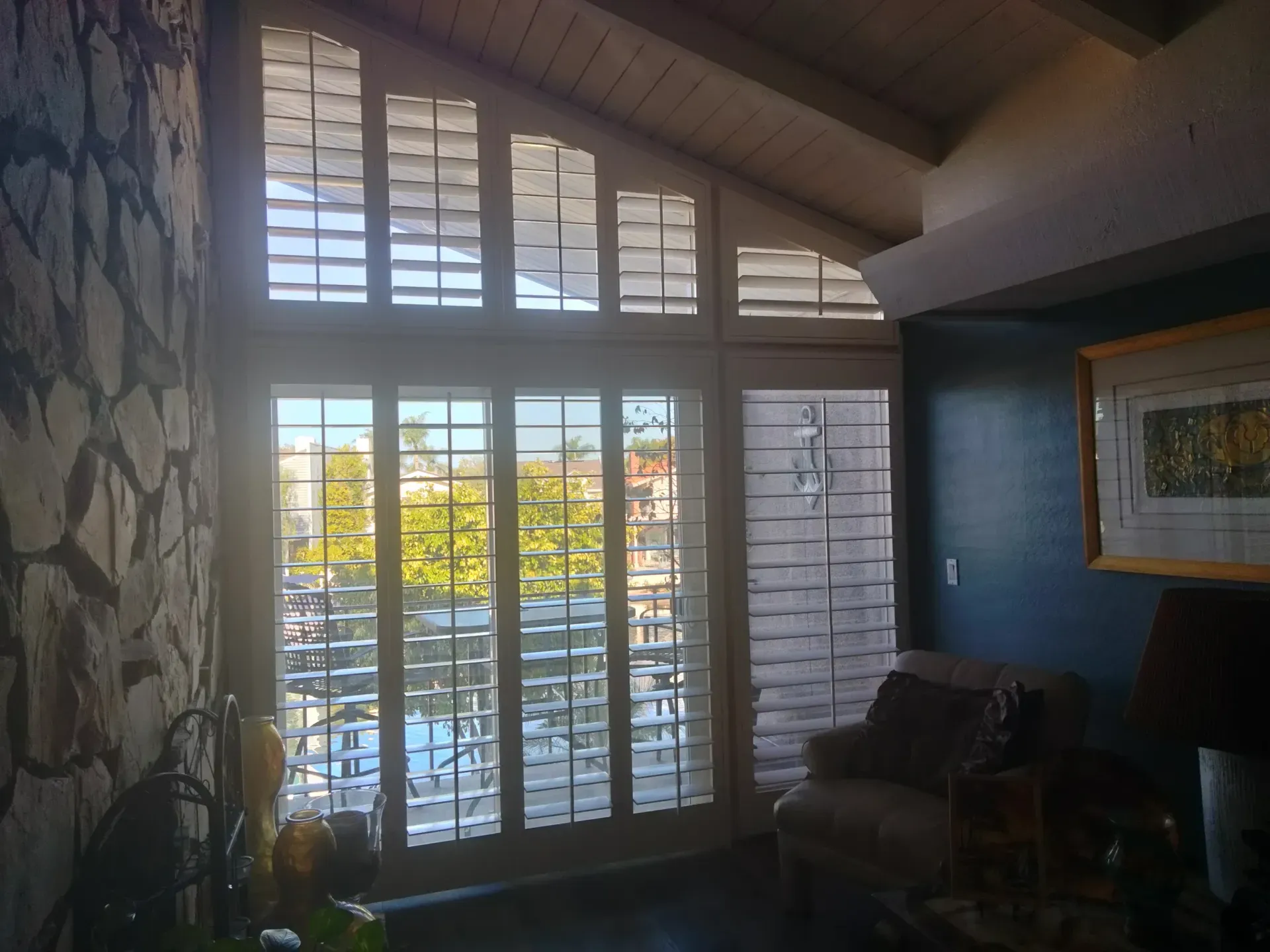 Custom plantation shutters built to follow a sloped vaulted ceiling
