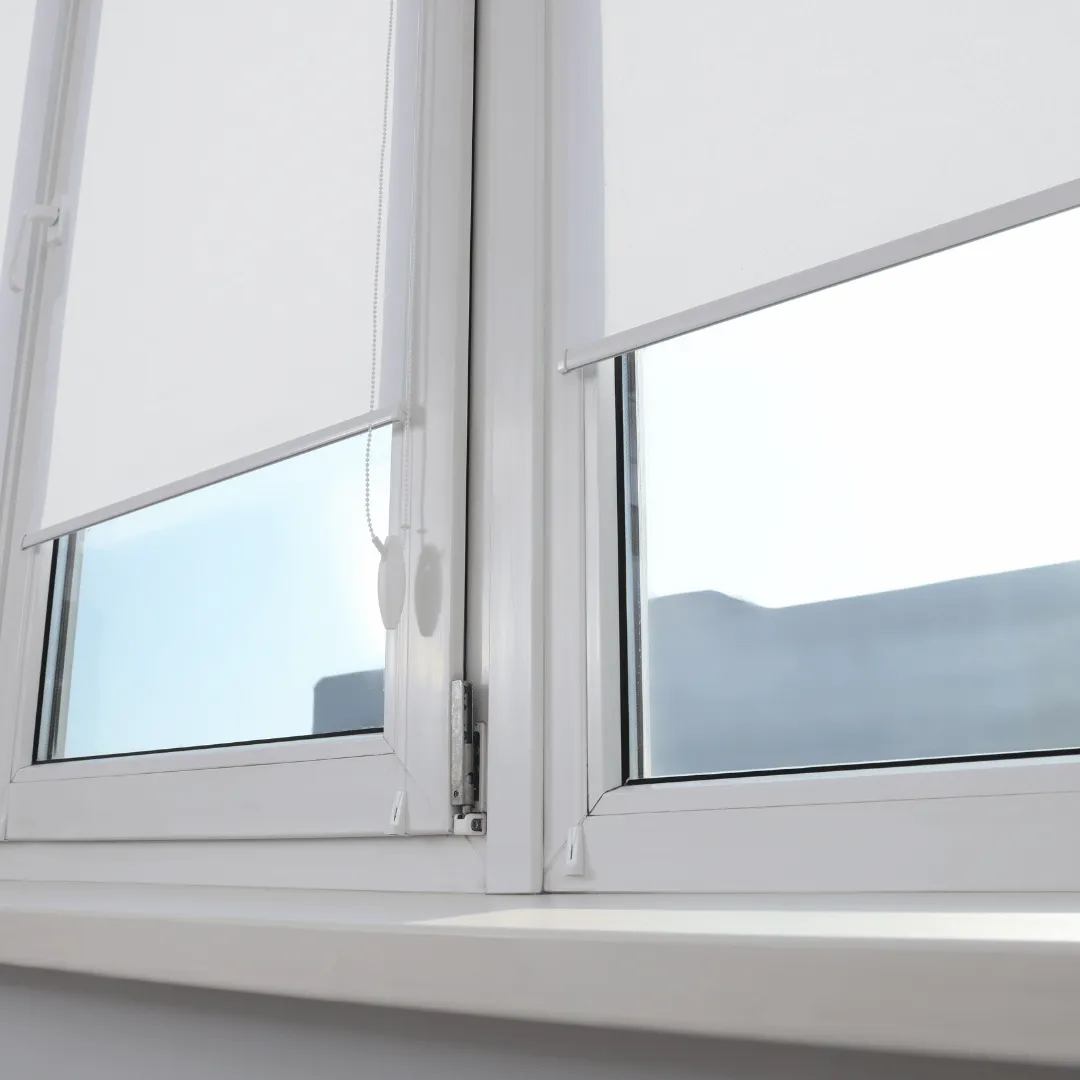 Light fabric roller-style shade lowered over a tilt-and-turn window