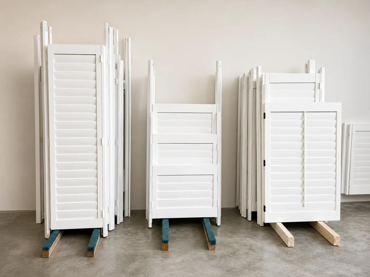 Rows of finished white plantation shutter panels staged for installation at the Lake Forest factory